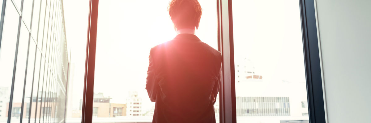 Man standing in front of a windowsill with the sun shining outlining silhouette
